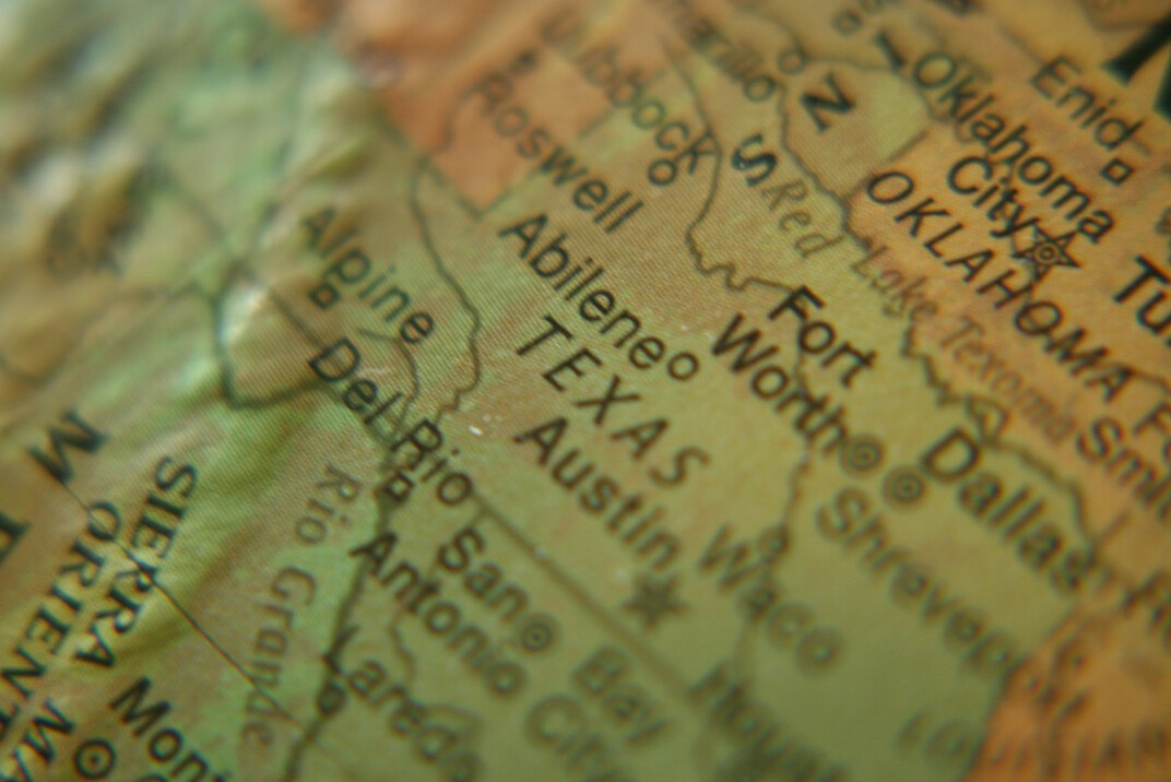 Magnifying glass over an old map of Uruguay on a desk