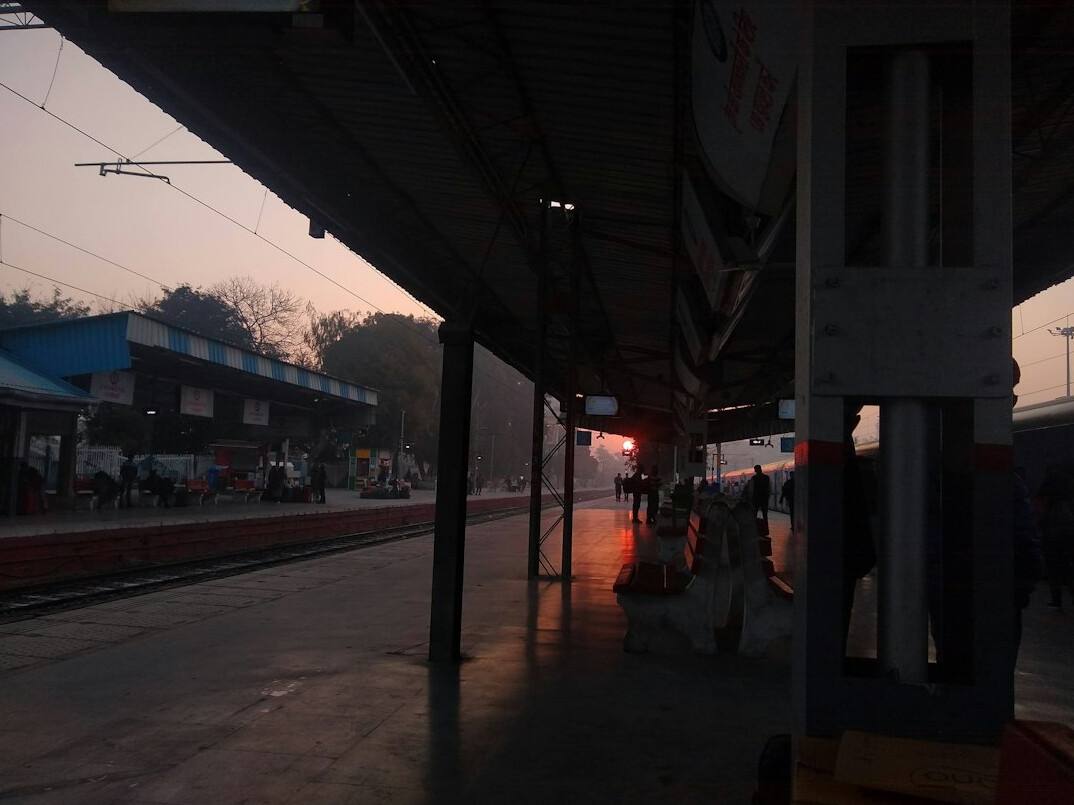Abandoned railway station platform with old clock at sunrise
