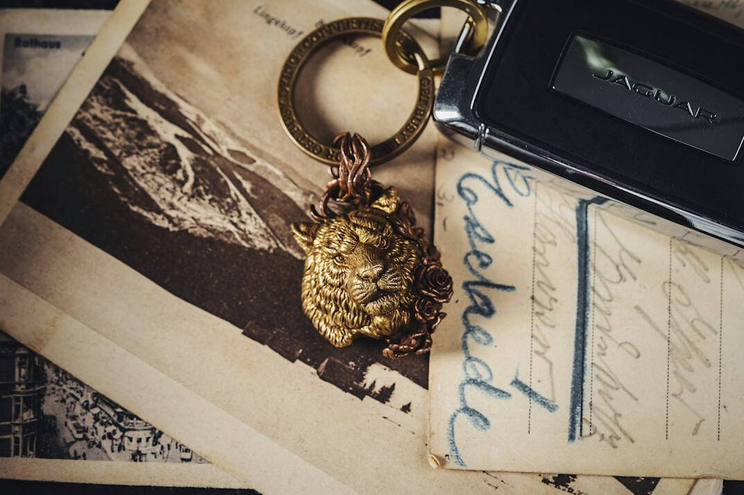 Old sealed letter with wax stamp next to a brass key on dark table