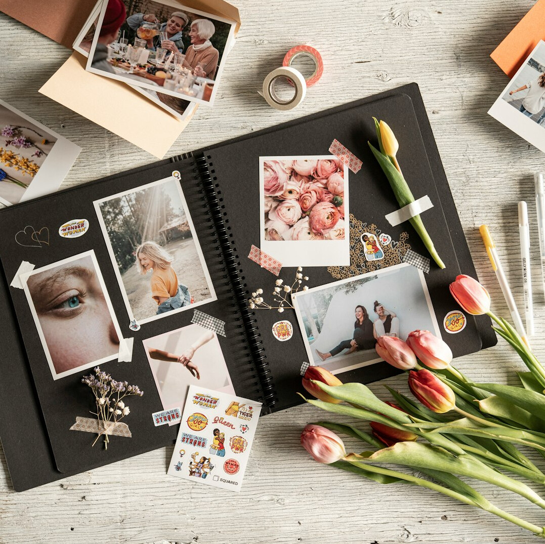 Open notebook with handwritten notes, old photographs and coffee on a desk